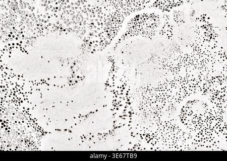 High-resolution texture of a white volcanic stone surface. Natural porous rock with small holes and organic patterns, similar to marble or pumice stone. Stock Photo