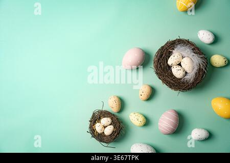 Happy Easter composition for easter design. Elegant Easter eggs and nests on mint background. Flat lay, top view, copy space. Stock Photo
