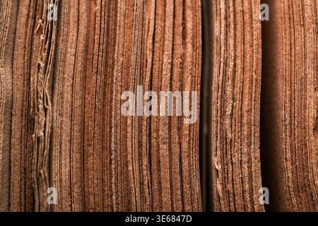 Close-up macro of stacked brown corrugated cardboard or paper layers showing textured edges and vertical lines, warm tones Stock Photo