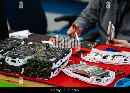 Caucasian person applying thermal paste and repairing graphics cards on a table Stock Photo