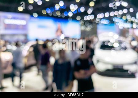 Abstract defocused shot of a car show featuring a vehicle silhouette and colorful bokeh lights in an exhibition hall. Ideal for automotive marketing, Stock Photo