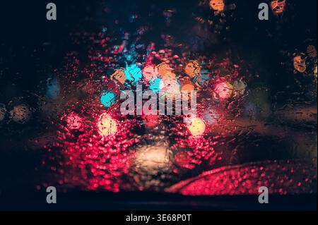 Abstract colorful bokeh raindrop on windshield in rainy day at night background Stock Photo