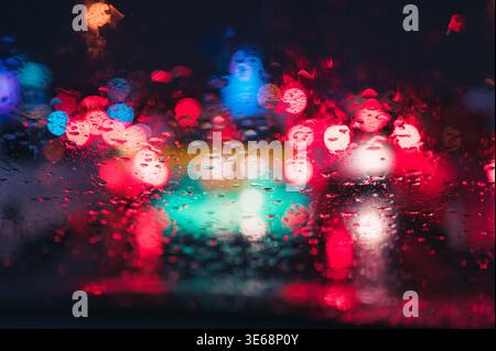 Abstract colorful bokeh raindrop on windshield in rainy day at night background Stock Photo