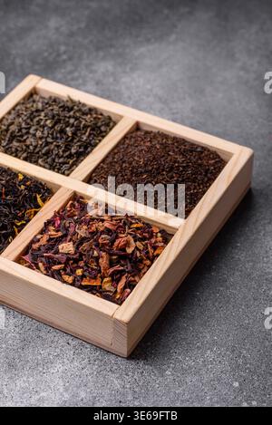 A box of various dry teas, black, green, herbal, and fruit, with flavored additives. A set of different tea varieties as a backdrop for your design Stock Photo