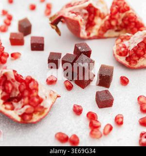 Homemade candied fruit jelly with pomegranate fruits on white. Marmalade jelly candies Stock Photo