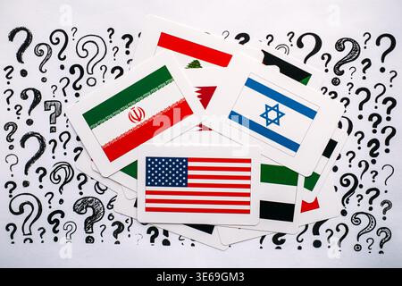 National flags of United States, Israel, Iran, and Lebanon lie scattered over paper with question marks. Global security uncertainty, future of Stock Photo