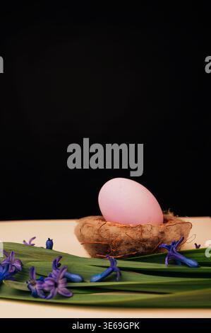 Artistic Composition Featuring Pink Egg In Nest Surrounded By Springtime Foliage And Flowers Stock Photo