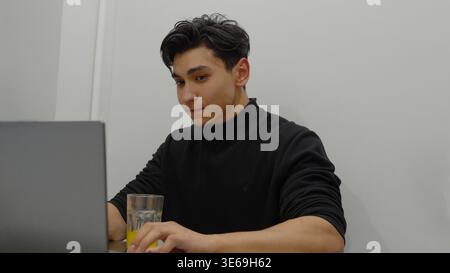 Young man working on laptop at home in the evening Stock Photo