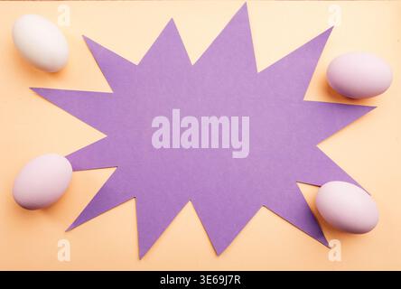 Decorative Seasonal Greeting Featuring Starburst Card And Colorful Pastel Eggs On Flat Beige Surface Stock Photo