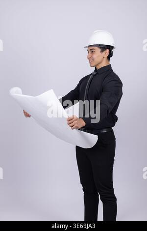 Engineer in white helmet looking at a blueprint Stock Photo