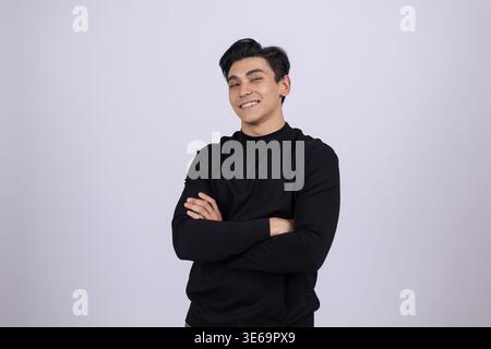 Man standing with arms crossed and smiling slightly Stock Photo
