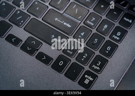 The keyboard shows various keys like enter, shift, and number keys in a workspace. It highlights the layout and design of a laptop keyboard. Stock Photo