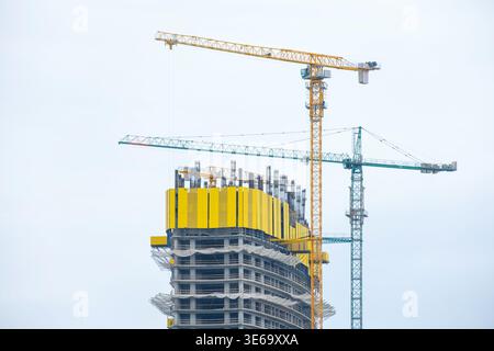 High rise building under construction with tower cranes and structural framework. Construction site, concrete floors and vertical elements, urban Stock Photo