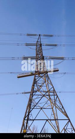 High-voltage electricity transmission tower with suspended maintenance platform Stock Photo