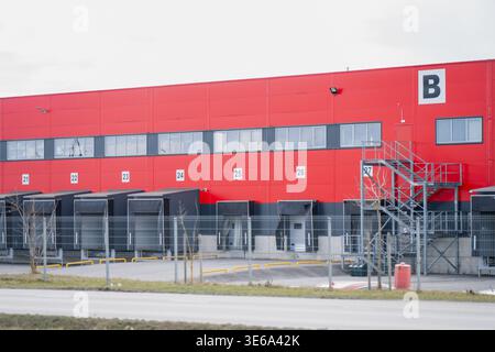 Modern distribution warehouse with dock doors and metal access stairs, illustrating freight handling, logistics property and industrial operations Stock Photo
