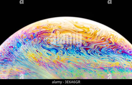 Macro photography captures the vibrant, swirling colors and fluid dynamics of a soap bubble's surface, creating an abstract visual spectacle Stock Photo