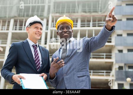 Architects talking about project documentation on construction plant Stock Photo