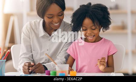 Enjoying Painting Time at Home With Mother and Daughter on a Sunny Afternoon Stock Photo