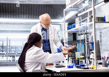 Diverse team of scientists collaborating in a modern laboratory, conducting experiments with advanced laboratory equipment. Research study for biotechnology, genetics and molecular biology. Stock Photo