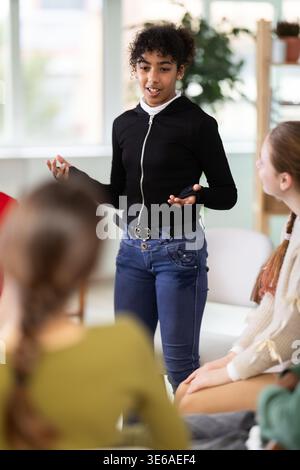 African American girl speaks to a group at a school class Stock Photo