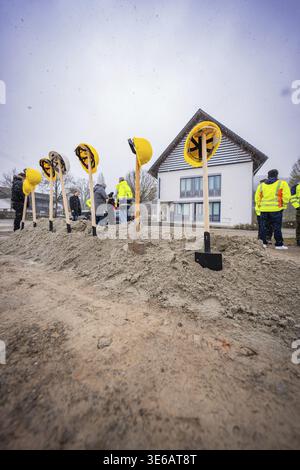 Spade with helmets in a pile of sand, several people and a building in the background, fiberglass groundbreaking, Glatten, Freudenstadt district, Germ Stock Photo