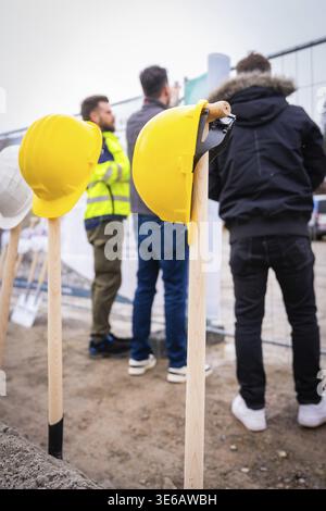 Yellow construction helmets on spade sticks, people wearing work clothes in front of a construction fence, fiberglass groundbreaking, Glatten, Freuden Stock Photo