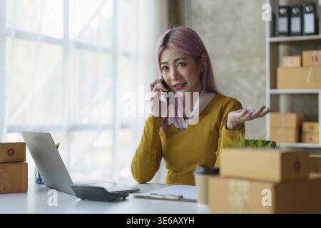 Young Asian woman entrepreneur successful with her SME business. Woman working at home Stock Photo