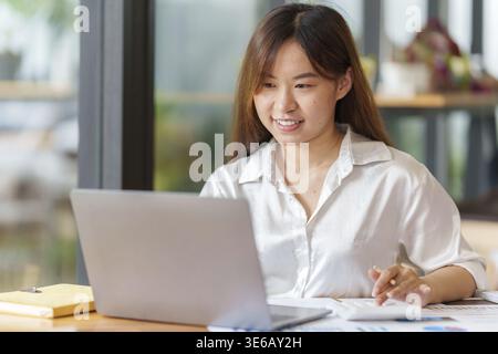 Portrait of Business woman hand using calculator to calculate the company's financial results and budget. Account Audit Concept Stock Photo