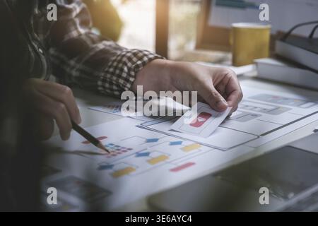 Closeup of female ux developer and ui designer about mobile phone app interface in living room at home.Creative digital development agency concept Stock Photo