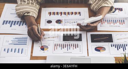 A businessman examines a financial report in paperwork, data from the company's operations, and the notion of a balance sheet Stock Photo