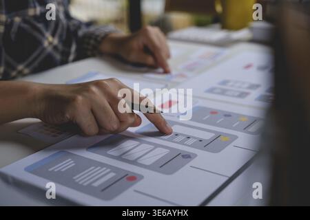 Closeup of female ux developer and ui designer about mobile phone app interface in living room at home.Creative digital development agency concept Stock Photo