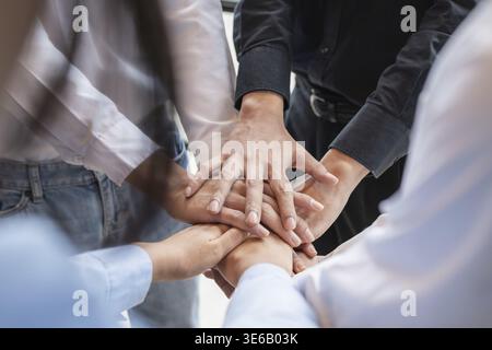 Group of business people putting their hands working together on wooden background in office. group support teamwork agreement concept Stock Photo