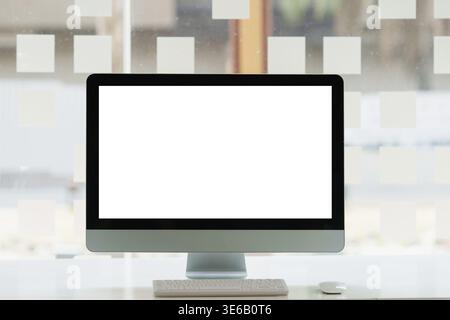 Front view of Mock up desktop computer with blank screen on desk at office Stock Photo