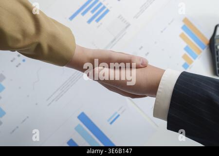 Close-up of a handshake between two business professionals, symbolizing agreement and collaboration in a financial context Stock Photo
