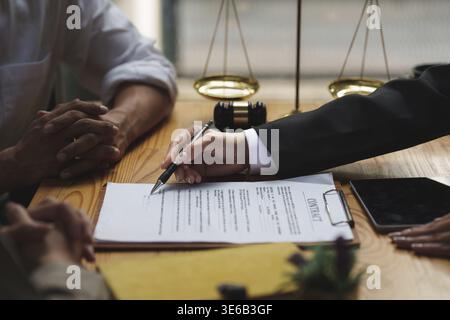 Business people and lawyers discussing contract papers with brass scale on wooden desk in office. Law, legal services, advice, Justice concept Stock Photo