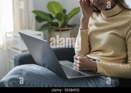 Frustrated stressed woman sitting on sofa at home Stock Photo