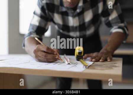 Architect man working with blueprints for architectural plan, engineer sketching a construction project, green energy concept Stock Photo