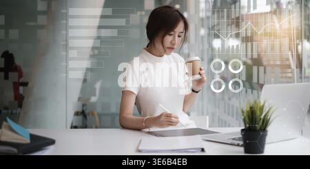Business woman using application in digital tablet with virtual financial icon on screen Stock Photo