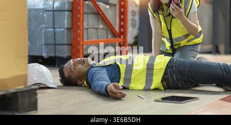 First aid by workmate. Working at warehouse. Male warehouse worker have accident Stock Photo
