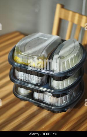 Stack of food containers on a wooden table Stock Photo