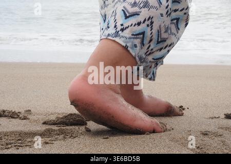 Walking on sandy beach during the day near the ocean Stock Photo
