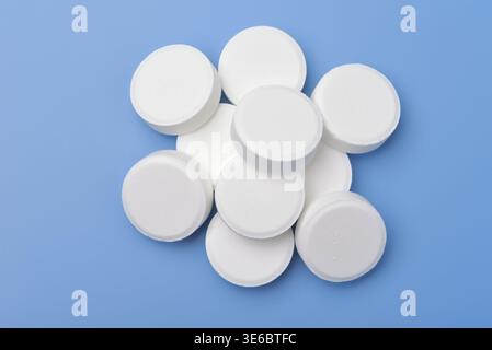 Top view of white medical pills isolated on blue background Stock Photo