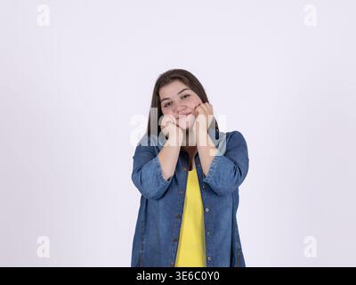 Happy woman holding her face in hands with joyful expression Stock Photo