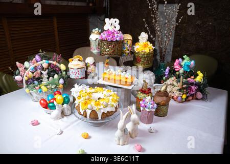 Festive Easter Table with Decorated Kulichi, Bunny Figurines and Colored Eggs Stock Photo