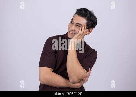 Young handsome man looking away with thoughtful facial expression Stock Photo