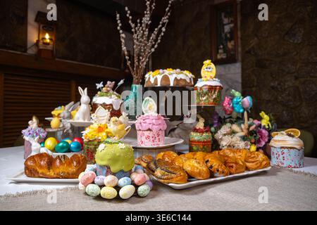 Festive Easter Table with Decorated Kulichi, Bunny Figurines and Colored Eggs Stock Photo
