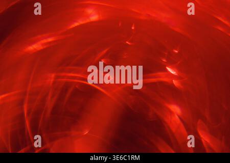 Abstract image featuring red light patterns with swirling shapes and textures, ideal for use in backgrounds or artistic design projects Stock Photo