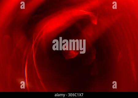Abstract image featuring a swirling red pattern with blurred light reflections, ideal for use in artistic projects or as a background element Stock Photo