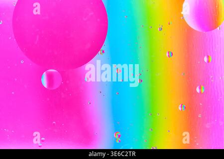 High contrast composition featuring large magenta oil sphere and scattered multi colored drops Stock Photo