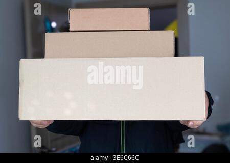 Delivery man holding cardboard boxes in hands. Concept of courier service, online shopping, fast shipping and logistics Stock Photo